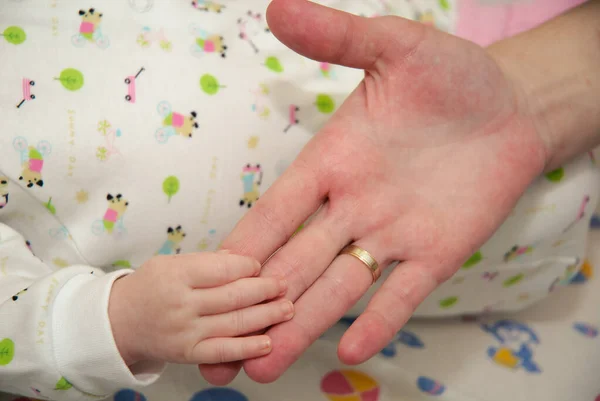 Uyuyan bebeği annenin eline ver, yakın plan. Annenin parmağındaki bir bebeğin aşırı yakınlaşması. Annenin parmağını tutan bebeklerin yakın çekimi. — Stok fotoğraf