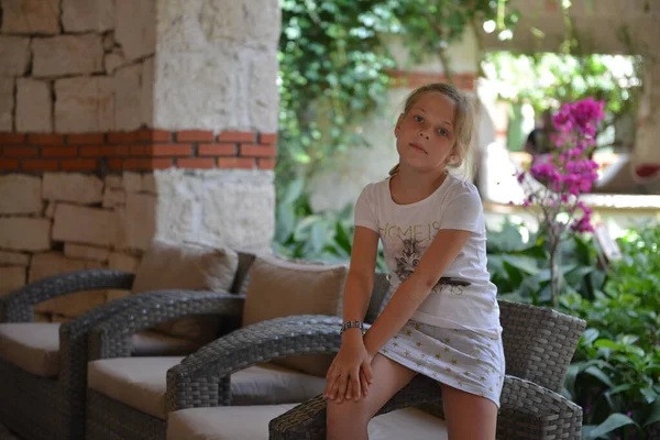 Menina relaxante em um grande banco ao ar livre parque tropical — Fotografia de Stock