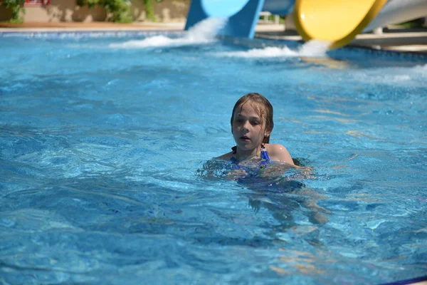 Little girl on water slide at aquapark during summer holiday — Stock Photo, Image