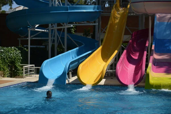 Маленька дівчинка на водяній гірці в аквапарку під час літніх канікул — стокове фото