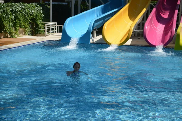 Маленька дівчинка на водяній гірці в аквапарку під час літніх канікул — стокове фото