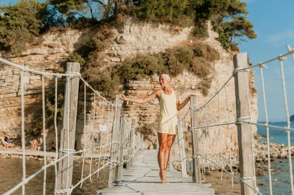 Retrato de modelo sexy posando en la playa rocosa. Chica atractiva con el cuerpo perfecto descansa y tiene buen tiempo de vacaciones. Concepto de viaje — Foto de Stock