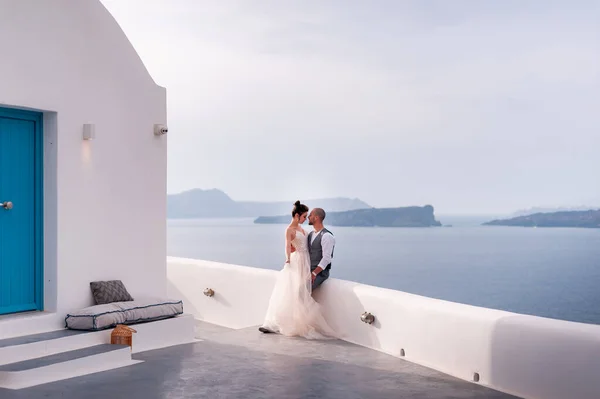 Beautiful bride and groom in their summer wedding day on greek island Santorini — Stock Photo, Image