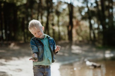Nehir kıyısında gülümseyen şirin bir çocuğun portresi..