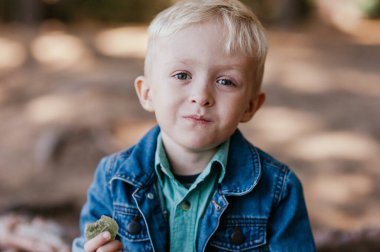 bir fincan çay açık havada tutan küçük bir çocuk. Çocuk çay içer