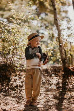 Sepetli şapkalı şık bir çocuk. Sonbaharda şapkalı ve sepetli bir çocuk.