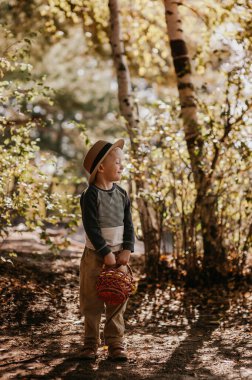 Sepetli şapkalı şık bir çocuk. Sonbaharda şapkalı ve sepetli bir çocuk.