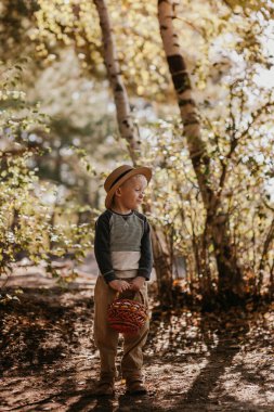 Sepetli şapkalı şık bir çocuk. Sonbaharda şapkalı ve sepetli bir çocuk.