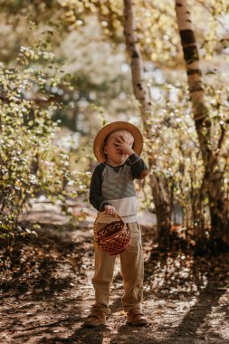 Sepetli şapkalı şık bir çocuk. Sonbaharda şapkalı ve sepetli bir çocuk.