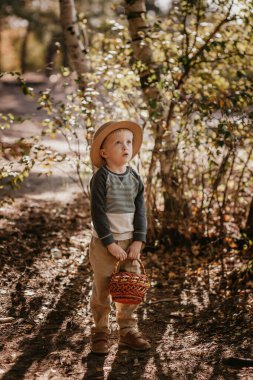 Sepetli şapkalı şık bir çocuk. Sonbaharda şapkalı ve sepetli bir çocuk.