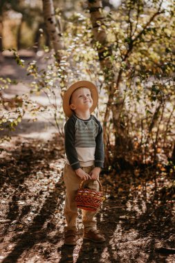 Sepetli şapkalı şık bir çocuk. Sonbaharda şapkalı ve sepetli bir çocuk.