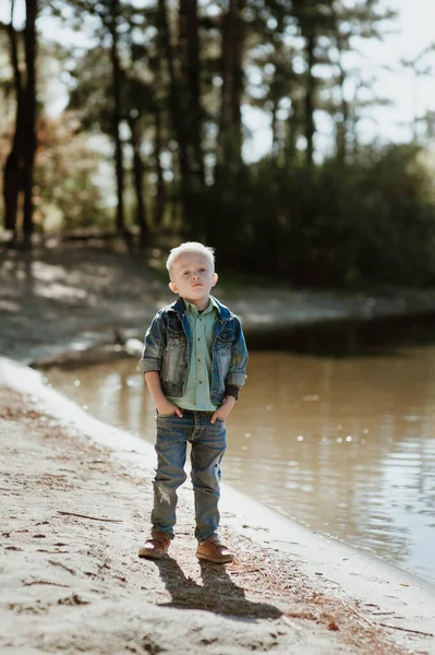 Porträt des süßen lächelnden Jungen an einem sommerlichen Flussufer. — Stockfoto