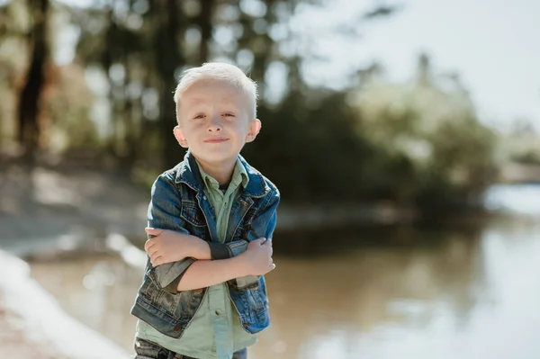 Retrato de lindo niño sonriente en una orilla del río de verano . — Foto de Stock