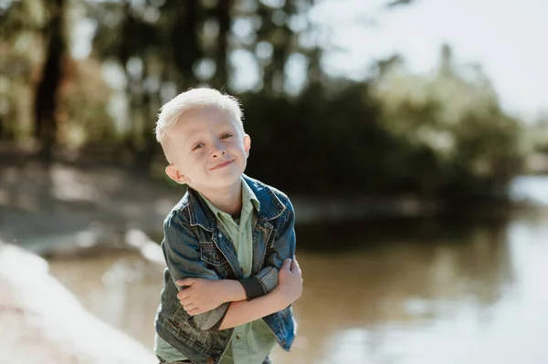 Retrato de lindo niño sonriente en una orilla del río de verano . — Foto de Stock