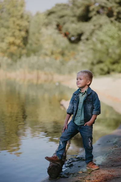 Portrait of cute smiling boy on a summer riverbank. — Stock Photo, Image