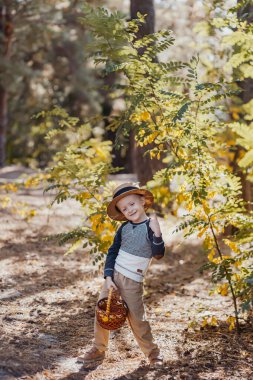 Sepetli şapkalı şık bir çocuk. Sonbaharda şapkalı ve sepetli bir çocuk.