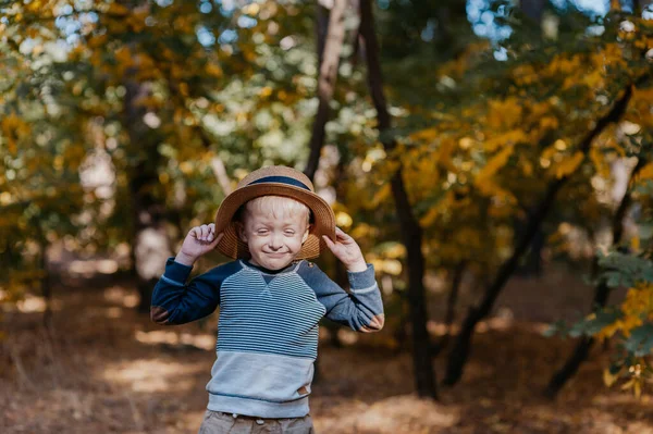 Niño con estilo en un sombrero con una cesta. niño en el parque en un sombrero con una cesta en otoño — Foto de Stock