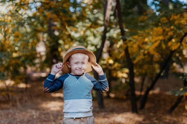 Rapaz elegante com um chapéu e um cesto. menino no parque em um chapéu com uma cesta no outono — Fotografia de Stock