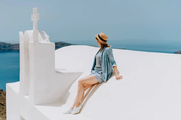 Santorini turismo mujer de vacaciones en Oia caminar. Chica visitando el famoso pueblo blanco con el mar Mediterráneo y cúpulas azules. Europa destino de verano. Hermosa chica en el tejado de — Foto de Stock