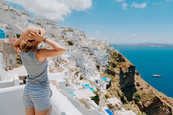 Chica hermosa de lujo en unas copas, en un hotel caro en una isla tropical, sobre un fondo de bahía de mar azul, en la terraza. Hermosa chica rubia en la isla de Santorini Grecia — Foto de Stock
