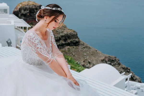 Romántico hermosa novia en vestido blanco posando en la terraza con el mar y las montañas en el fondo — Foto de Stock