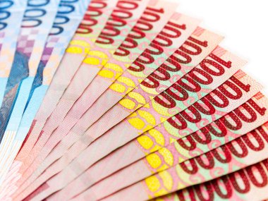 Endonezya Rupiah (IDR) banknotlar beyaz zemin üzerine yığınları.