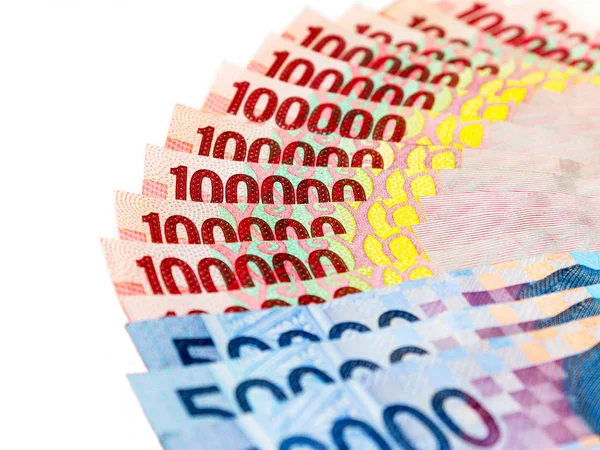 Endonezya Rupiah (IDR) banknotlar beyaz zemin üzerine yığınları.