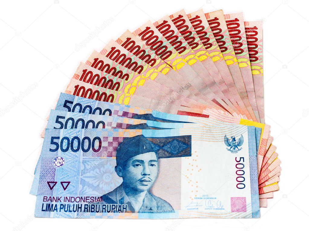 Piles of Indonesian Rupiah (IDR) banknotes on the white background.