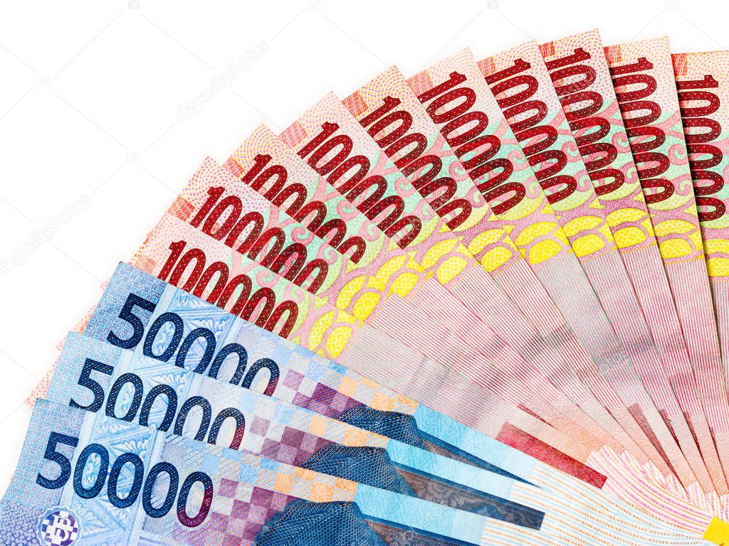 Piles of Indonesian Rupiah (IDR) banknotes on the white background.