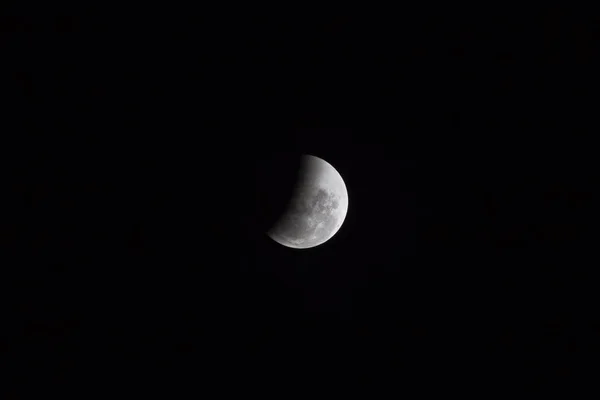 Moon view in the end (penumbra) of period of rare lunar eclipse phenomena which named Super Blue Blood Moon. The moon surface was half covered by the earth shadow.