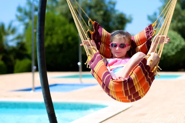 快乐的小女孩放松在吊床旁边的游泳池 可爱的孩子在美丽的别墅或度假胜地享受暑假 家庭与孩子的豪华暑假 — 图库照片