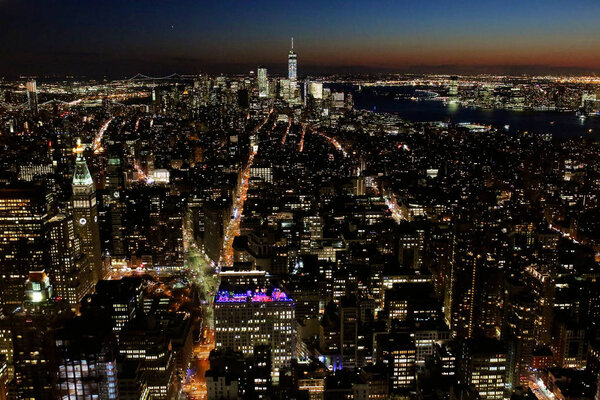 Late evening or early night view from the top of the Empire State Building towards Manhattan, Broadway, Financial District with One World Trade Centre as well as Brooklyn bridge and Jersey City.