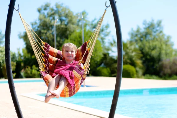 快乐的小女孩放松在吊床旁边的游泳池 可爱的孩子在美丽的别墅或度假胜地享受暑假 家庭与孩子的豪华暑假 免版税图库图片