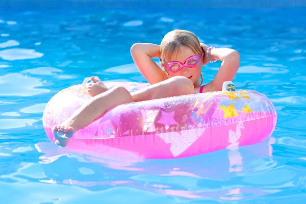 Felice Bambina Rilassante Anello Gonfiabile Nella Piscina All Aperto Ragazzo Foto Stock