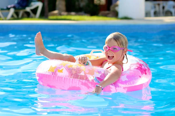 快乐的小女孩放松在充气环在露天游泳池 可爱的孩子享受暑假在美丽的度假胜地或私人别墅 家庭与儿童的豪华夏季目的地 免版税图库图片