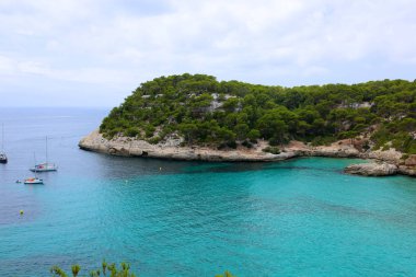 Cala Mitjana, Minorca, Balear Adası, İspanya güzel koyunda. Turkuaz deniz suyu Yelkenli tekneler. Yaz aile tatil için mükemmel bir yer.