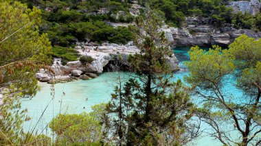 Cala Mitjana, Minorca, Balear Adası, İspanya güzel koyunda. İnsanlar yüzme ve Şnorkelle Dalma turkuaz deniz suyu. Yaz aile tatil için mükemmel bir yer.