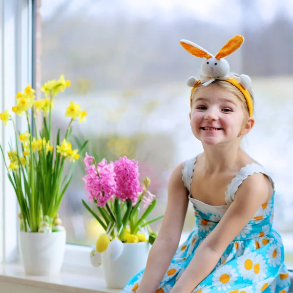 小女孩装饰的窗口与春天的花朵和复活节彩蛋 照看植物的孩子 幼儿照顾风信子和水仙花 复活节家庭内饰和装饰 — 图库照片