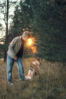 adam bir kovboy şapkası köpeği koyar.