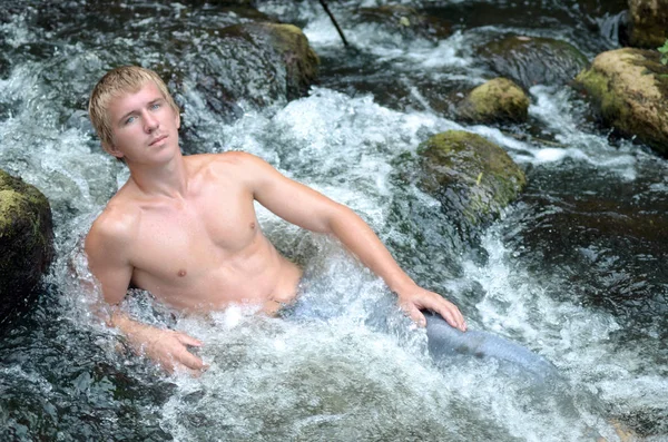 Knappe Man Rustend Rivier Liggen Een Waterval Onder Stenen — Stockfoto