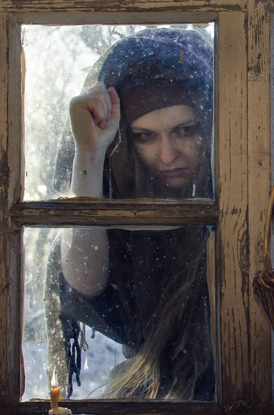 冬の夜に窓に非常に不親切な農村農民女性ノック 彼女は悪いニュースをもたらす — ストック写真