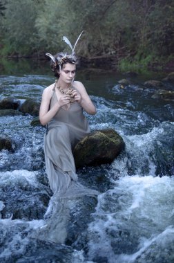 sabırsızlıkla bir rock nehir hızlı akıntılar ortasında oturan deniz kızı dekorasyon deniz kabukları, bu kötü ne çeker? yakalamak ve nehir derinliklerinde boğulmak kim istiyor? o-ebilmek