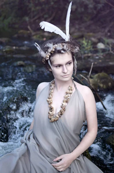 gri bir ipek elbise, bir kolye deniz salyangoz kabukları ve perevsidit ve onun nehirde dinlenme headdress nehir perisi