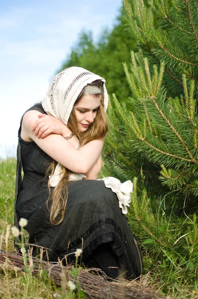 悲伤的年轻女子在松树下 拥抱自己的肩膀 — 图库照片