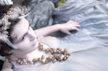 Genç kadın bir çelenk tüyler ve kabukları