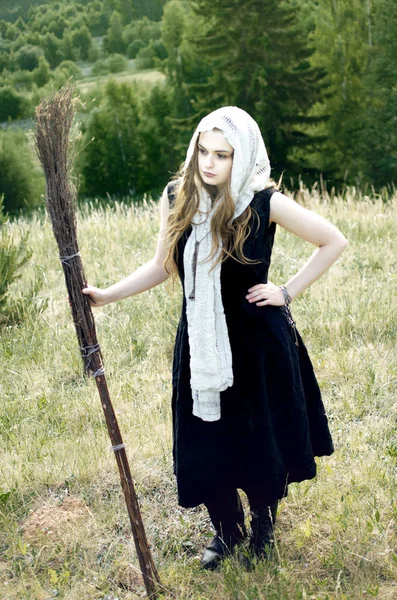 黒のドレスとほうきで白いハンカチで若い魔女 — ストック写真