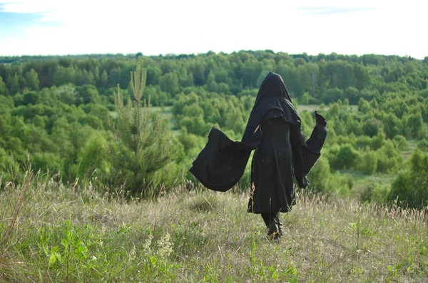 Женщина Ведьма Черном Плаще Смотрит Лес Горы Покрытой Травой — стоковое фото