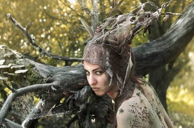 Keçe bir takım elbise ve makyaj doğal ilaçlar ve orman enkaz kadında, ağaçların altında eski bir bahçede orman perisi gizler