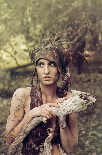 Keçe bir takım elbise ve makyaj doğal ilaçlar ve orman enkaz kadında, ağaçların altında eski bir bahçede orman perisi gizler