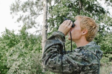 Dürbün mesafe içine bakarak genç turist adam